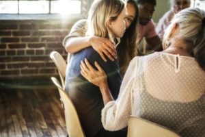woman being comforted in group therapy program
