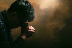 a man prays as his faith helps him in his addiction recovery