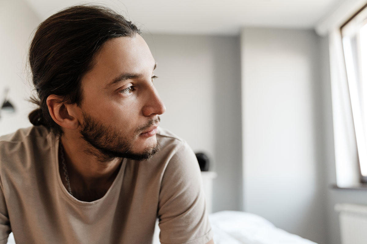 a man suffering from dysthymia considers the benefits of seeking dysthymia treatment at a mental health treatment facility